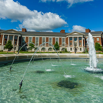 A campus building viewed through a fountain. Link to Tangible Personal Property A campus building viewed through a fountain. Link to Tangible Personal Property